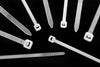 A collection of clear nylon cable ties of various sizes laid out on a dark background.