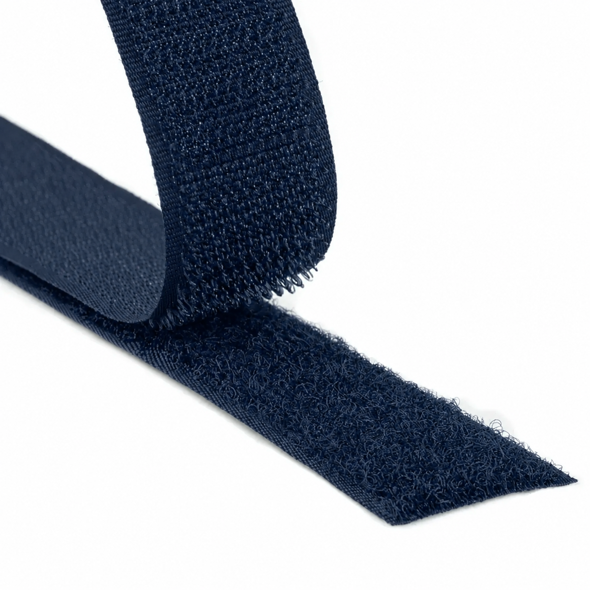 Close-up of a navy hook and loop fastener tape showing both hook and loop sides on a white background
