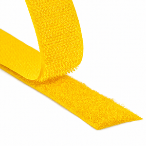 Close-up of a yellow hook and loop fastener tape showing both hook and loop sides on a white background